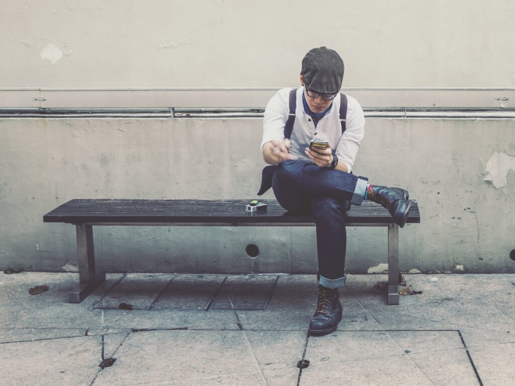 jeune-homme-assis-sur-un-banc-et-un-smatphone-images-photos-gratuites-libres-de-droits